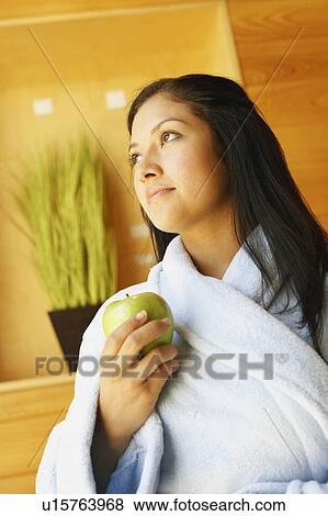 Close-up of a young woman holding an apple View Large Photo Image Stock Photo - Close-up of a young woman holding an apple. Fotosearch