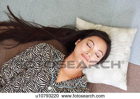 Close-up of a young woman lying with her eyes closed View Large Photo Image Stock Image - Close-up of a young woman lying with her eyes closed. Fotosearch