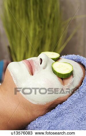 Stock Image - Close-up of a young woman wearing a facial mask. Fotosearch