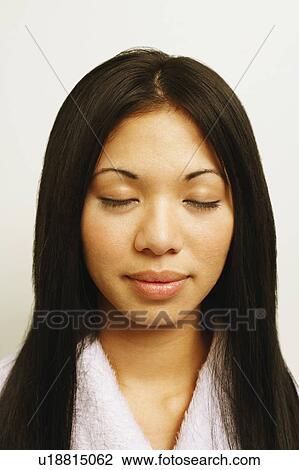 Stock Image - Close-up of a young woman with her eyes closed. Fotosearch