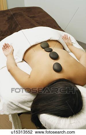 Stock Image - High angle view of a woman getting hot stone therapy. Fotosearch