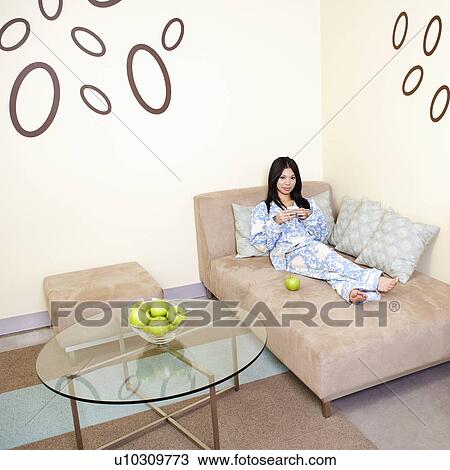 High angle view of a young woman reclining on a couch View Large Photo Image Stock Image - High angle view of a young woman reclining on a couch. Fotosearch