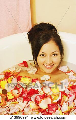 Portrait of a young woman in a bathtub filled with flower petals View Large Photo Image Picture - Portrait of a young woman in a bathtub filled with flower petals. Fotosearch