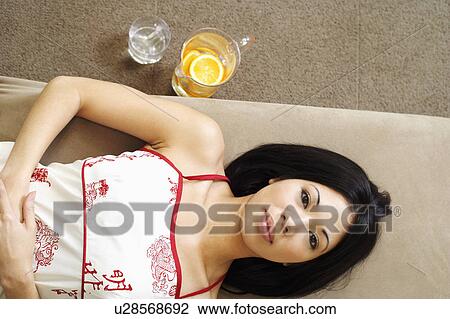 Portrait of a young woman lying on a couch View Large Photo Image Stock Image - Portrait of a young woman lying on a couch. Fotosearch