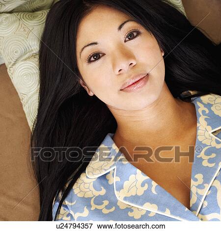 Portrait of a young woman lying on a couch View Large Photo Image Stock Photo - Portrait of a young woman lying on a couch. Fotosearch