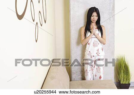Young woman greeting with her eyes closed View Large Photo Image Picture - Young woman greeting with her eyes closed. Fotosearch