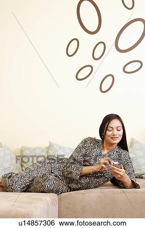 Stock Photograph - Young woman using a hand held device. Fotosearch