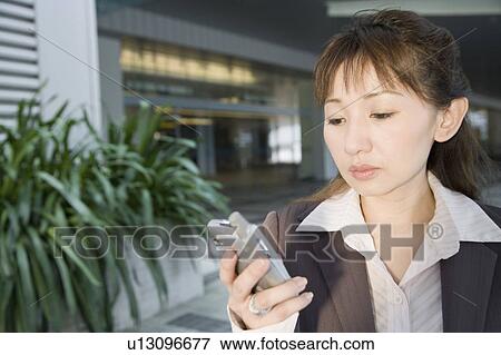 Stock Photo - Close-up of a businesswoman holding a mobile phone. Fotosearch