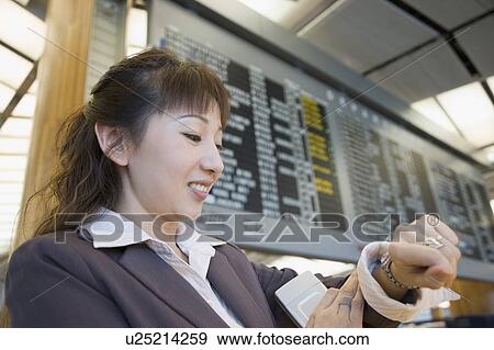 Stock Photo - Close-up of a businesswoman looking at her wristwatch. Fotosearch