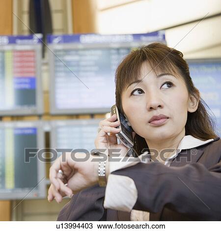 Close-up of a businesswoman talking on a mobile phone and checking the time View Large Photo Image Stock Image - Close-up of a businesswoman talking on a mobile phone and checking the time. Fotosearch