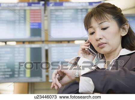 Close-up of a businesswoman talking on a mobile phone and checking the time View Large Photo Image Stock Image - Close-up of a businesswoman talking on a mobile phone and checking the time. Fotosearch