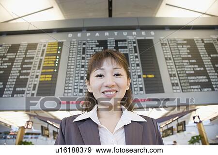 Stock Photo - Portrait of a businesswoman at an airport and smiling. Fotosearch