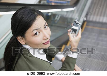 Stock Image - Portrait of a businesswoman holding a mobile phone. Fotosearch