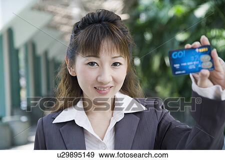 Stock Photo - Portrait of a businesswoman showing a credit card. Fotosearch