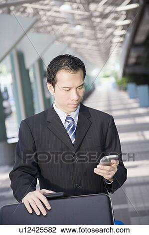 Businessman using a palmtop View Large Photo Image Stock Image - Businessman using a palmtop. Fotosearch