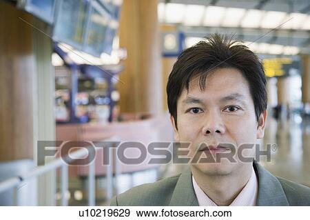 Stock Photo - Portrait of a businessman at an airport lounge. Fotosearch