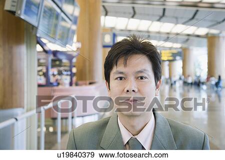 Stock Photo - Portrait of a businessman at an airport lounge. Fotosearch