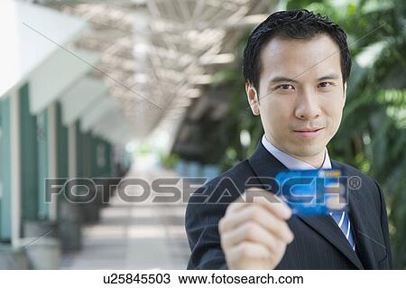 Portrait of a businessman showing a credit card View Large Photo Image Stock Image - Portrait of a businessman showing a credit card. Fotosearch