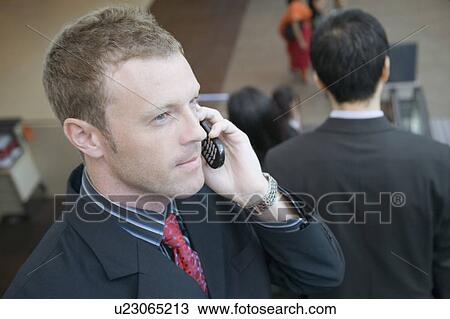 Stock Image - Side profile of a businessman talking on a mobile phone. Fotosearch
