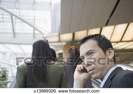 Side profile of a businessman talking on a mobile phone View Large Photo Image Stock Photograph - Side profile of a businessman talking on a mobile phone. Fotosearch