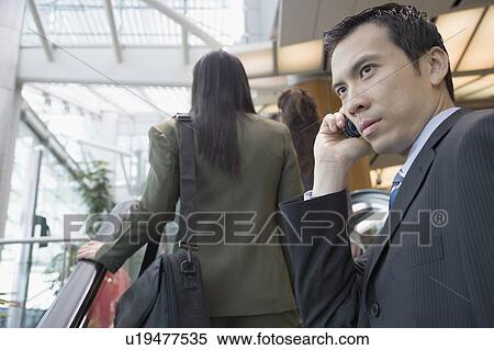 Side profile of a businessman talking on a mobile phone View Large Photo Image Stock Photography - Side profile of a businessman talking on a mobile phone. Fotosearch