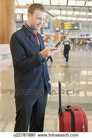 Side profile of a businessman using a mobile phone at an airport lounge View Large Photo Image Stock Image - Side profile of a businessman using a mobile phone at an airport lounge. Fotosearch