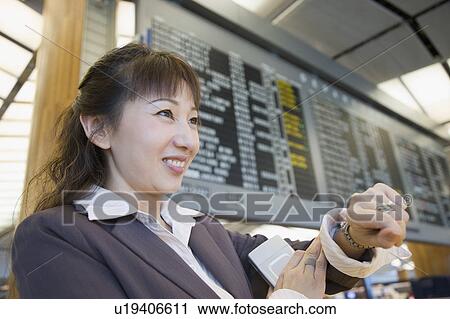 Stock Image - Close-up of a businesswoman at an airport and smiling. Fotosearch