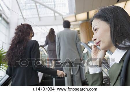 Low angle view of a businesswoman talking on a mobile phone View Large Photo Image Picture - Low angle view of a businesswoman talking on a mobile phone. Fotosearch