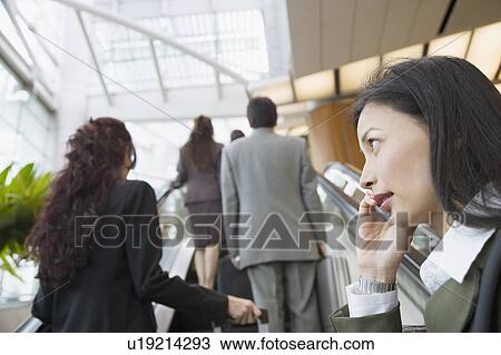 Low angle view of a businesswoman talking on a mobile phone View Large Photo Image Stock Image - Low angle view of a businesswoman talking on a mobile phone. Fotosearch