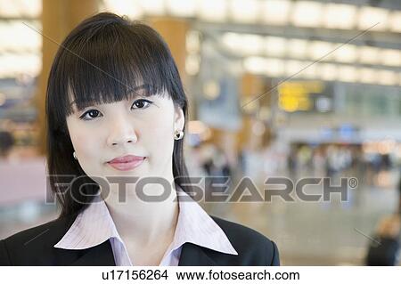 Picture - Portrait of a businesswoman at an airport lounge. Fotosearch