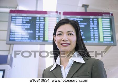Picture - Portrait of a businesswoman smiling at an airport. Fotosearch