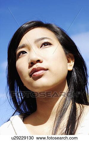Close-up of a young woman looking away View Large Photo Image Stock Image - Close-up of a young woman looking away. Fotosearch
