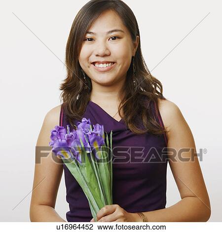 Portrait of a young woman holding a bouquet of flowers View Large Photo Image Stock Image - Portrait of a young woman holding a bouquet of flowers. Fotosearch