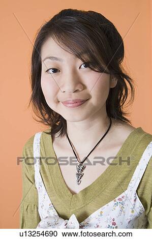 Stock Image - Portrait of a young woman smirking. Fotosearch