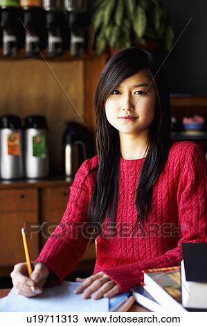 Portrait of a young woman writing on a sheet of paper View Large Photo Image Stock Image - Portrait of a young woman writing on a sheet of paper. Fotosearch