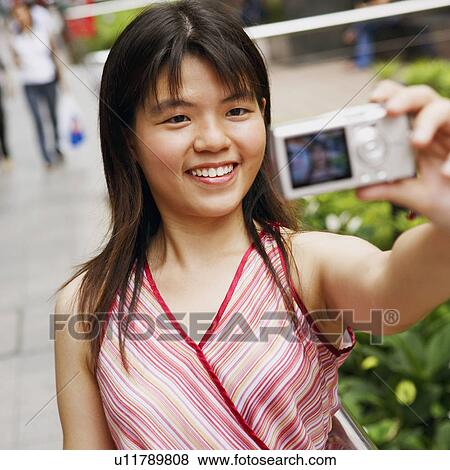 Young woman taking a picture of herself View Large Photo Image Stock Photo - Young woman taking a picture of herself. Fotosearch