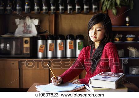 Young woman writing on a sheet of paper View Large Photo Image Stock Image - Young woman writing on a sheet of paper. Fotosearch