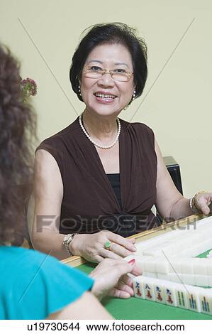 Portrait of a senior woman playing mahjong View Large Photo Image Picture - Portrait of a senior woman playing mahjong. Fotosearch