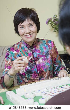 Stock Image - Portrait of a senior woman playing with blocks with another person. Fotosearch