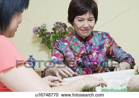 Senior woman and a mature woman playing mahjong View Large Photo Image Stock Image - Senior woman and a mature woman playing mahjong. Fotosearch