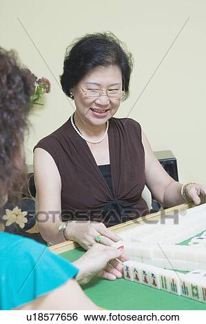 Stock Photograph - Senior woman playing mahjong. Fotosearch