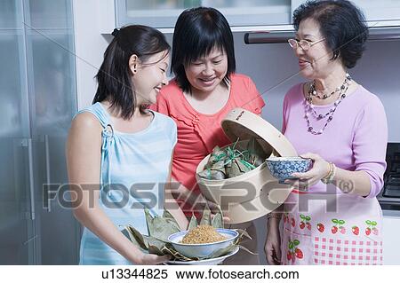 Stock Photography - Senior woman with her daughter and granddaughter in a kitchen. Fotosearch