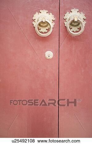 Stock Photo - Close-up of two doorknockers with a keyhole on a door. Fotosearch