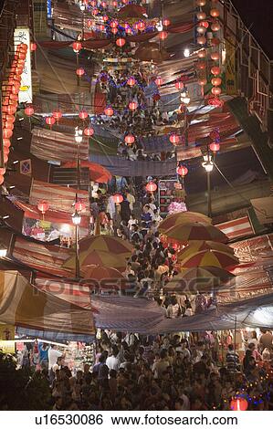 Stock Photograph - High angle view of a crowd walking on the street at night decorated with Chinese lanterns, Chinatown, Singapore. Fotosearch