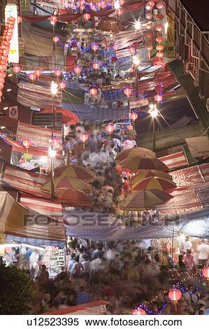 Stock Photography - High angle view of a crowd walking on the street at night decorated with Chinese lanterns, Chinatown, Singapore. Fotosearch