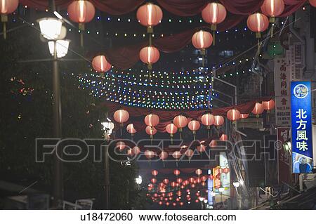 Stock Image - Low angle view of Chinese lanterns on the street lit up at night, Chinatown, Singapore. Fotosearch