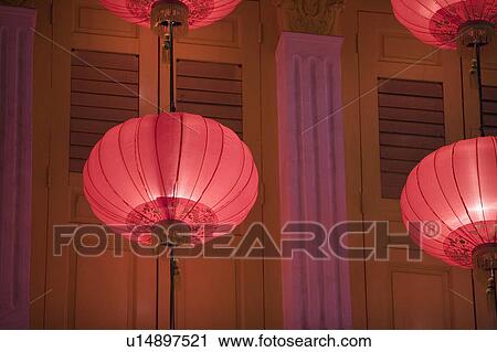 Stock Image - Low angle view of Chinese lanterns hanging in front of a building. Fotosearch