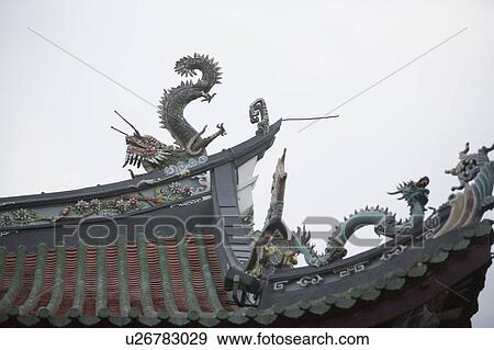 Stock Photo - Low angle view of dragon sculptures on the roof of a temple. Fotosearch