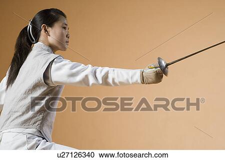 Stock Image - Close-up of a female fencer fencing. Fotosearch