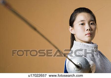 Close-up of a female fencer fencing View Large Photo Image Stock Photo - Close-up of a female fencer fencing. Fotosearch